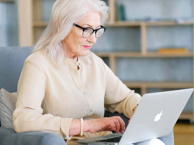 Idosa em sessão de psicoterapia online pelo laptop em casa