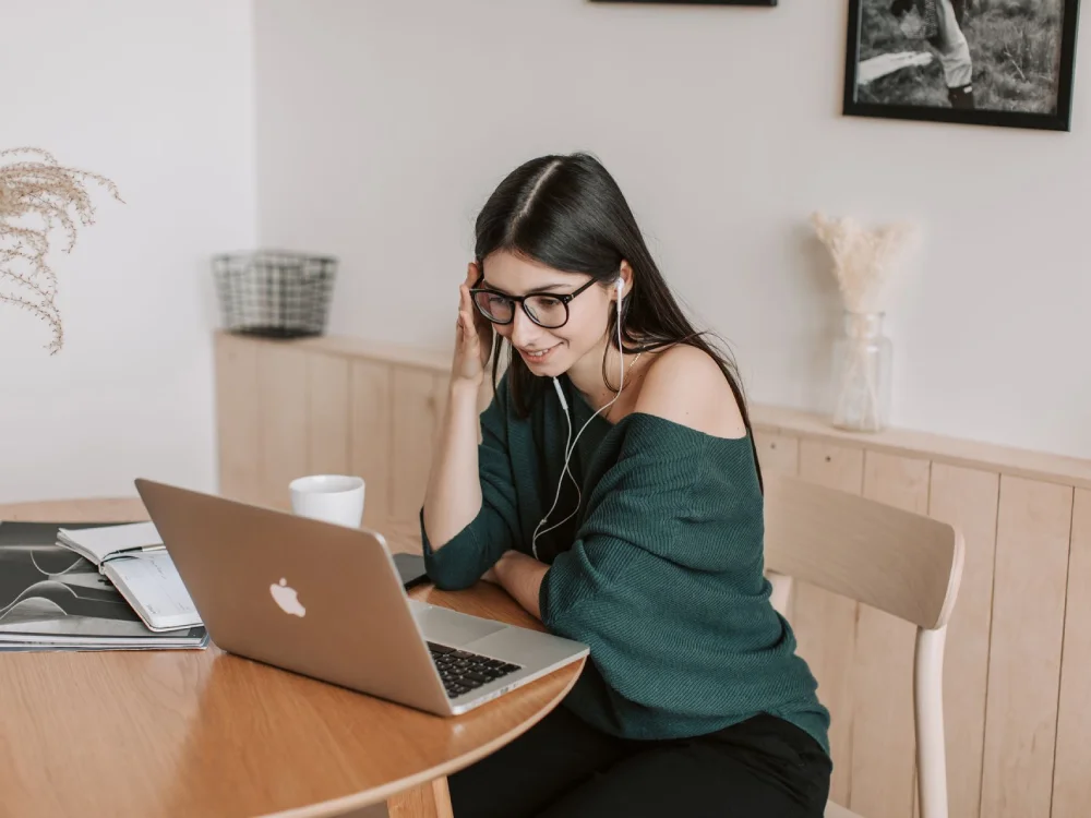 Mulher em terapia online por videochamada, com fones de ouvido e laptop